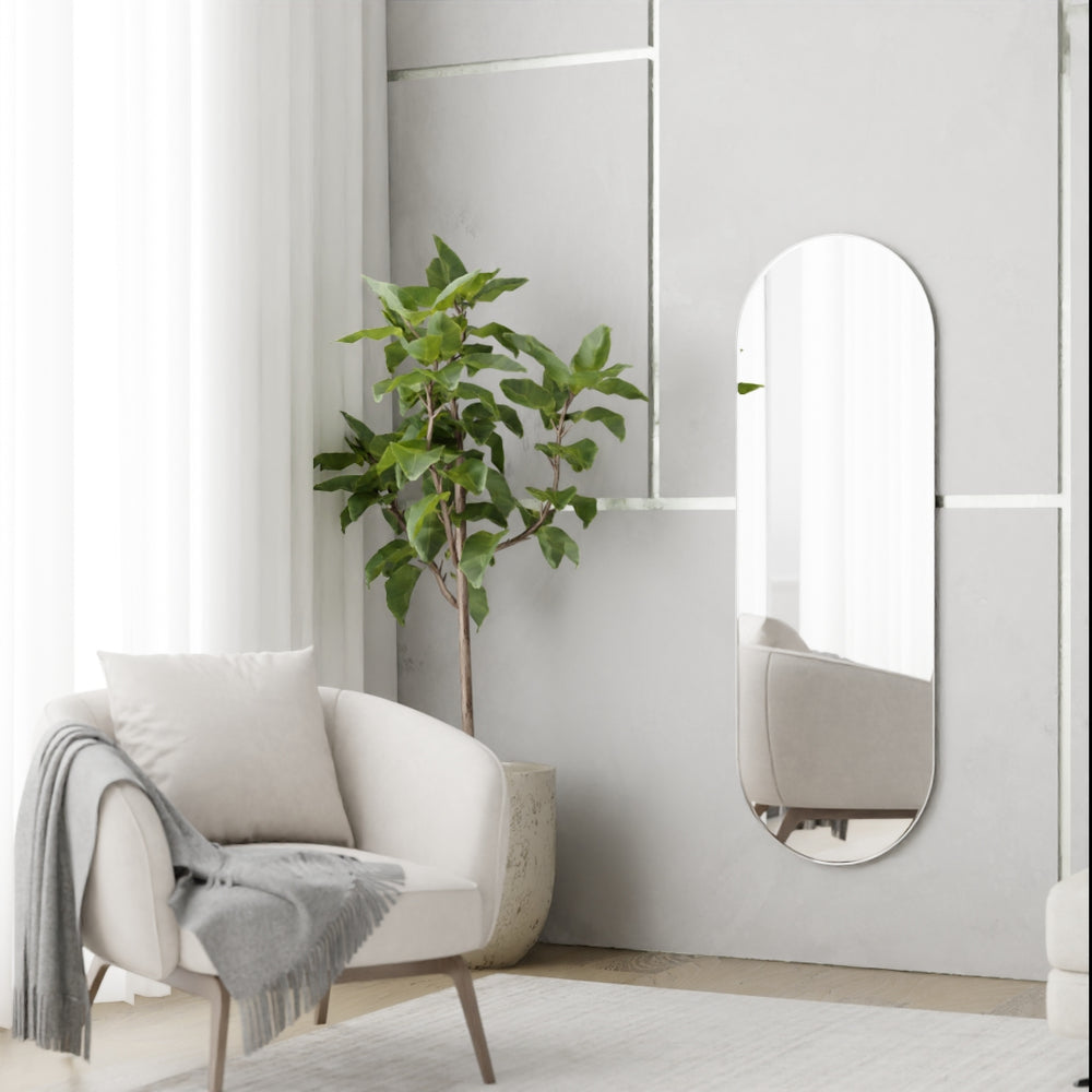 Pill-shaped frameless wall mirror in minimalist living room