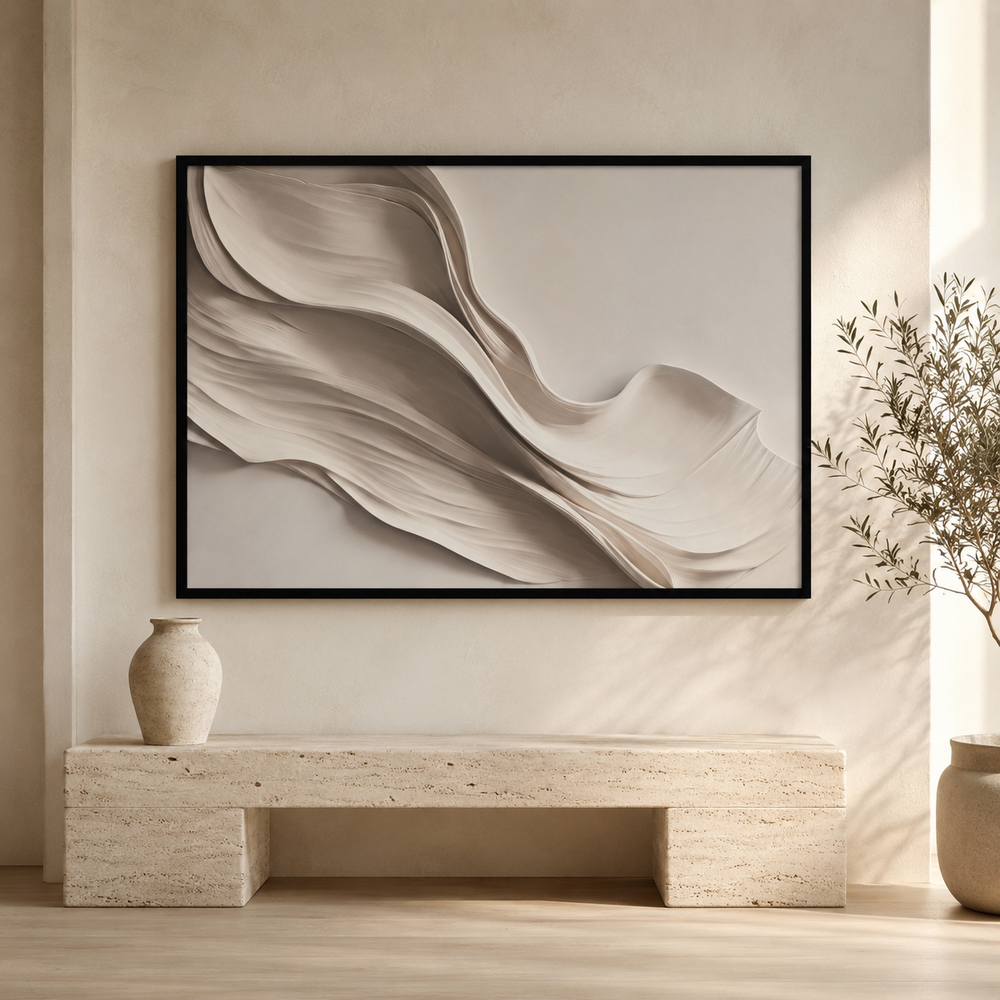 Drift beige and taupe wall art in a black frame, flowing fabric-like folds, styled above a travertine bench