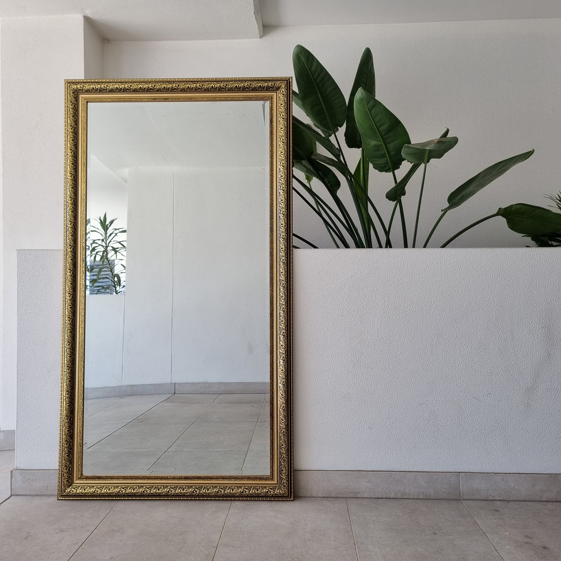 Gold and black ornate full-length mirror with a decorative frame