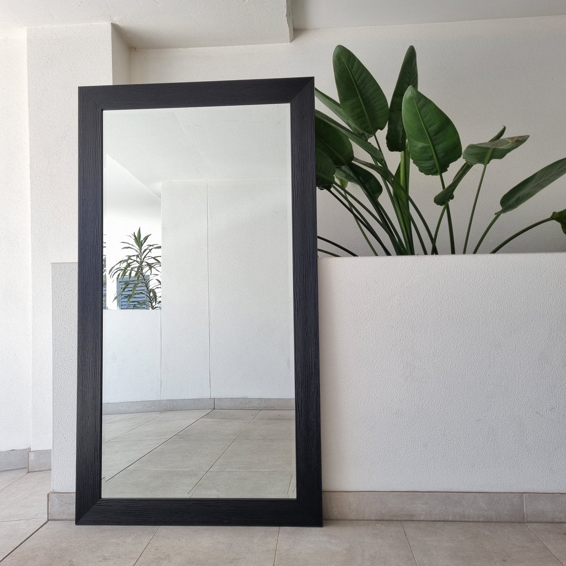 Black textured full-length mirror with a moulded black frame